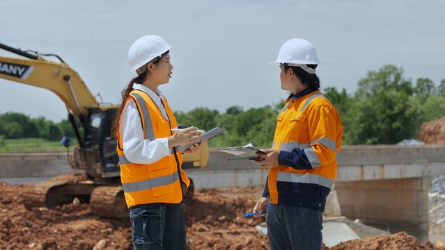 Civil Engineering Team Discussing Bridge Construction Project at Active Work Site