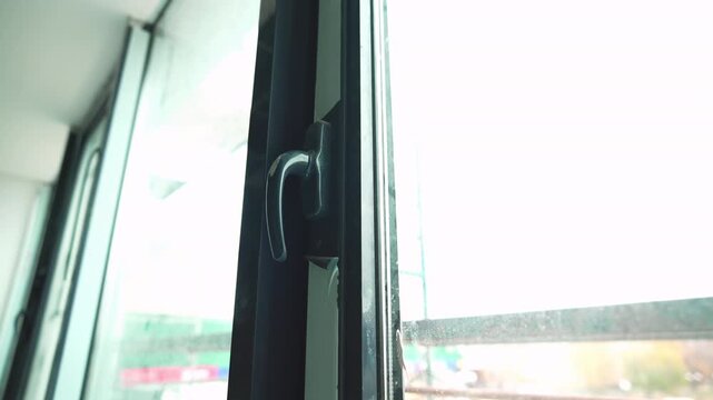 Modern metal plastic window with black frame and handle in building closeup. Glass structure with polyvinyl chloride plastic profile