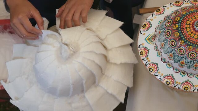 Woman hands making a pith hat or pith helmet from mulberry paper, craftsmanship in the Northern Thailand.