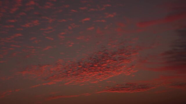 Evening sky timelapse with red clouds passing by until dark.