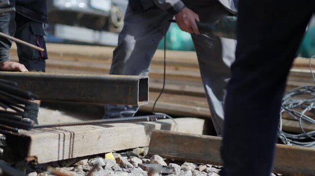 Worker uses disk saw to cut square metal beam edge at construction site closeup. Employee engages in metalwork at industrial facility