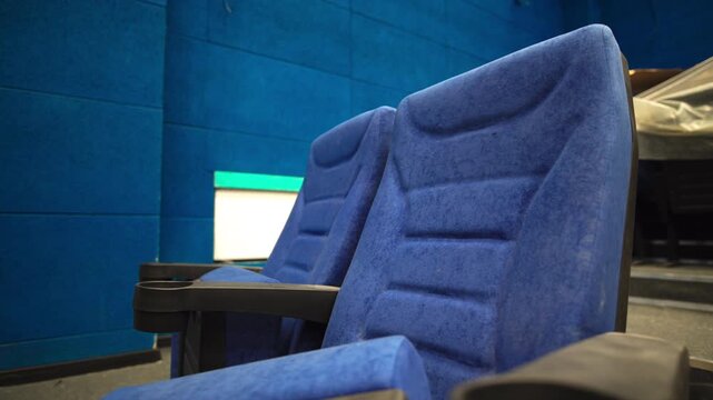 Blue spectator seats installed in renovated hall of cinema. Modern chairs prepared to arrange in movie theater auditorium at maintenance