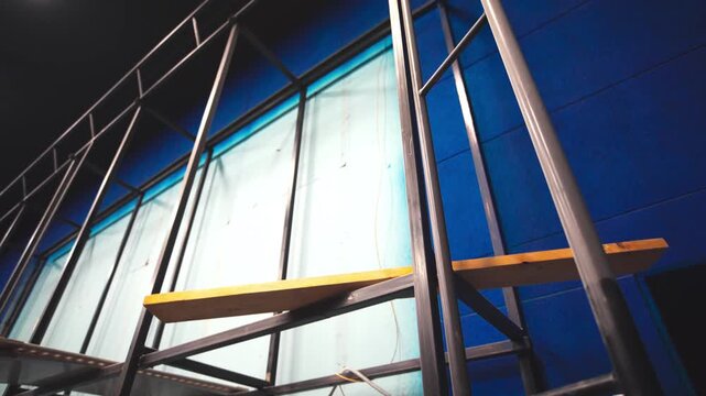 Empty steel screen frame on wall of cinema hall low angle shot. Special equipment used for movie translation in modern entertainment center