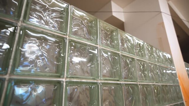 Glass block wall and column separates enclosure in different rooms closeup. Public building interior design translucent lobby partition