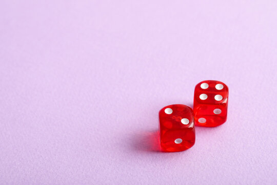 Red game dices on lilac background
