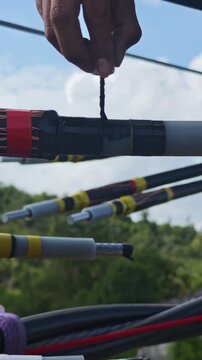 Close up video of worker hands in safety gloves applying semiconducting stress control mastic on a twisted aerial cable joint, industrial electrical power grid distribution network maintenance.
