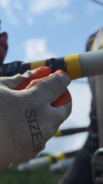 Close up video of worker hands in safety gloves applying semiconducting stress control mastic on a twisted aerial cable joint, industrial electrical power grid distribution network maintenance.