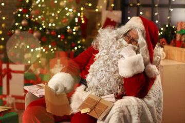 Fototapeta premium Santa Claus with letters sleeping in armchair at home on Christmas eve