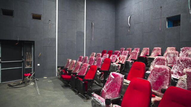 Small cinema hall with cozy chairs and frame for screen at entertainment center. Maintenance of modern movie theater with equipment
