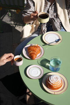 Couple Having Coffee and Fresh Croissants at Outdoor Cafe Table