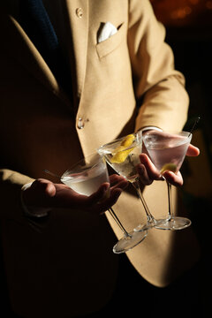 Bartender in Suit Holding Three Classic Martini Cocktails