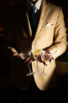 Bartender in Suit Holding Three Classic Martini Cocktails
