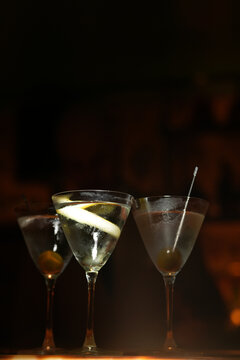 Three Classic Martini Cocktails on Dark Moody Bar Counter