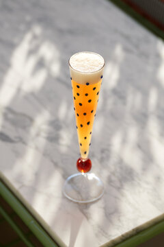 Orange Sparkling Cocktail in Polka Dot Flute on Marble Terrace Table