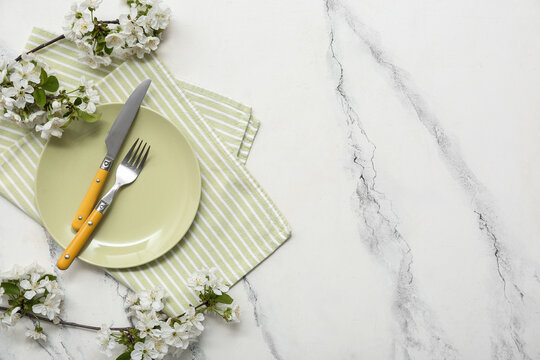Beautiful table setting with blooming branches on white background