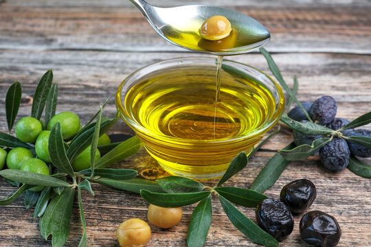organic olive oil pouring in a glass bowl	