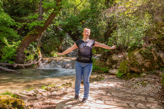 Travel Woman happy in a park spring near water