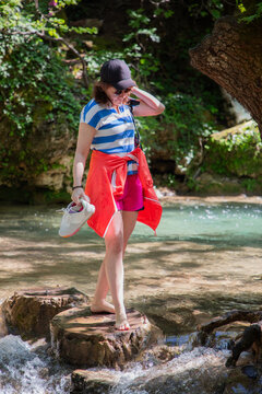 Travel Woman happy in a park spring near water