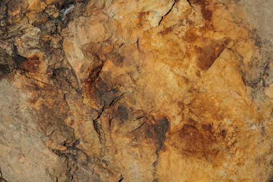 vista dettagliata di una superficie rocciosa naturale dalle tonalit&agrave; di marrone e giallo chiaro e scuro