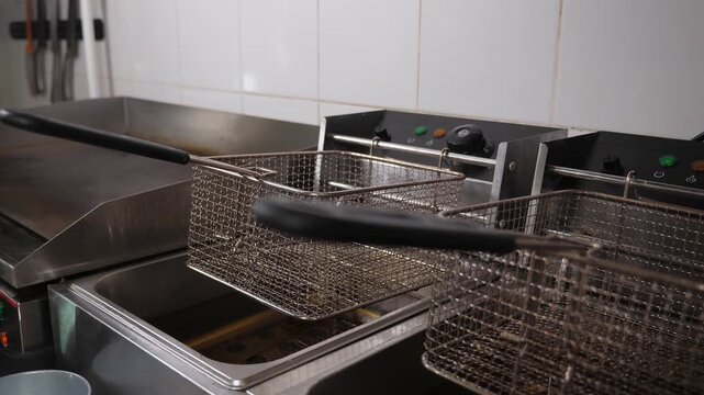 Close-up of empty deep-fryers in the restaurant's industrial kitchen. Two empty fryers for French fries and nuggets in the kitchen of a fast food restaurant.