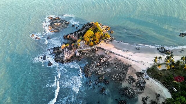 aerial view of parai tenggiri tropical island in bangka with turquoise ocean, rocky shoreline, sandy beach, and peaceful coastal scenery