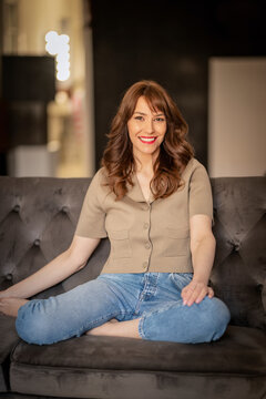 Portrait of smiling mature woman sitting on couch at home