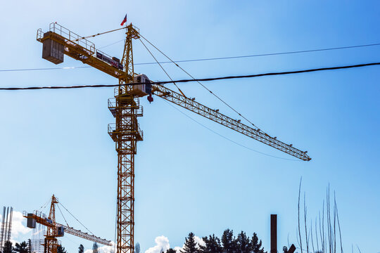 A tall yellow crane rises above an active construction zone in Angol, Chile