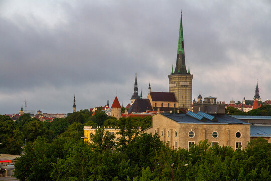 Scenic morning view of the medieval Tallinn old town skyline and gothic St. Olaf church spire from the Linnahall terrace under an overcast sky in Estonia.