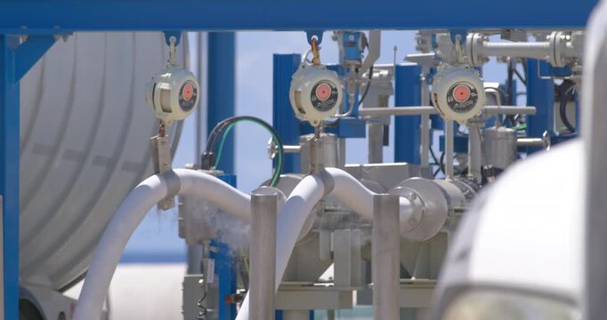 Daytime static close-up shot showing high-pressure LPG valve connection emitting cold vapor during gas transfer at Coastal Petroleum Dominicana terminal in San Pedro de Macoris, Dominican Republic