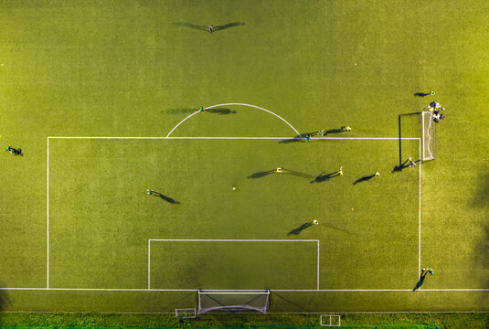 Aerial view of soccer players on the field at the Gdansk University of Physical Education and Sport with long shadows cast on the green grass in Gdansk, Pomeranian Voivodeship, Poland.