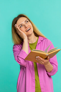 Middle-aged woman flips pages of a book with a focused and calm look, deeply engaged in reading and absorbing information. Girl on blue background shows interest, concentration and thoughtful gesture.
