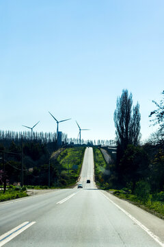 Two vehicles travel up a long rural road in the Biob&iacute;o Region of Chile
