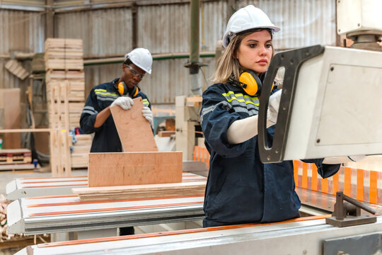 Diverse engineering team collaborates set precise specifications for timber board thickness before production highlights smart factory technology, timber processing, and manufacturing engineering 
