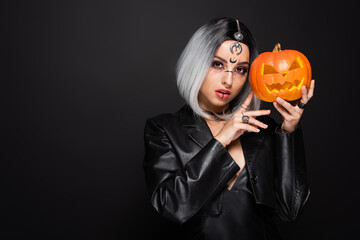 Naklejka premium Gothic witch with crescent moon symbol poses for Halloween portrait