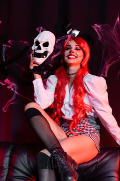 Creepy clown cosplay with bright red hair for Halloween celebration