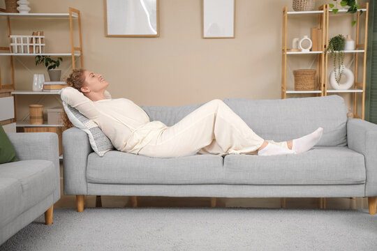 Beautiful young woman relaxing on sofa at home. Day off concept
