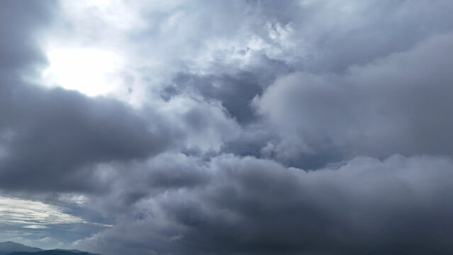 Aerial view of dark, heavy storm clouds filling the sky over the landscape of Sukabumi Regency, West Java, Indonesia.