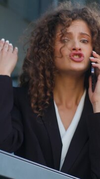 Emotional furious Caucasian business woman yelling talking conflict with mobile phone misunderstanding disagreement communication problem businesswoman angry talk female girl on office balcony in city