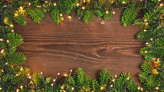 Christmas Lights and Tree Branches Frame on Wooden Background. Seamless Loop.