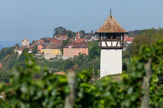 A picturesque view of a historic vineyard tower with the old town and castle of Meersburg on the hillside at Lake Constance.