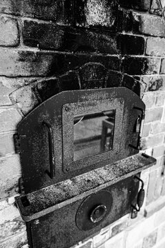 Vintage cast iron stove built into a brick wall in black and white