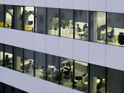 Aerial view of sparsely occupied office spaces in a modern commercial building