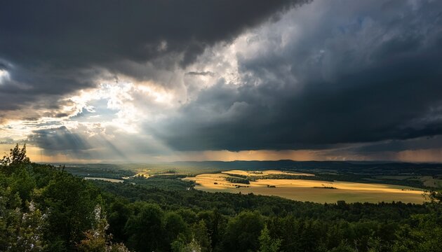 Dramatic Storm Clouds Rolling In Over A Landscape With Rays Of Sunlight Breaking Through