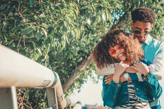 romantic latin couple hugging happily outdoors