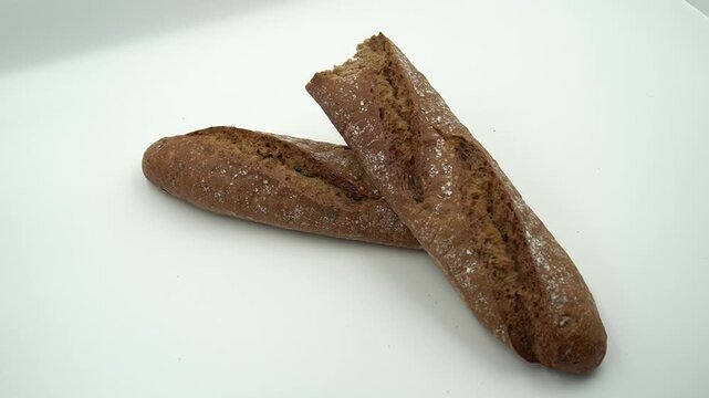 Artisan whole wheat French baguette loaf isolated on a white background