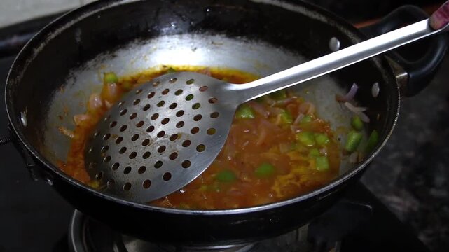 Fresh onion tomato capsicum masala cooking in a wok, creating a rich and flavourful curry base.