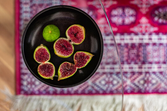Halved figs placed on the table over a traditional oriental rug