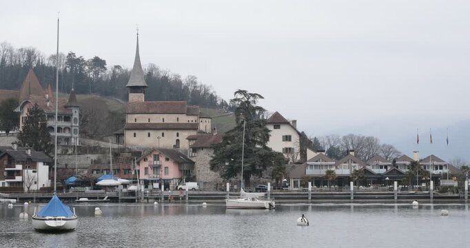 Spiez Castle and Marina on Lake Thun, Switzerland,overlooking the marina and calm waters of Lake Thun in Spiez, Switzerland. Historic architecture, sailboats and reflections create a picturesque lakes
