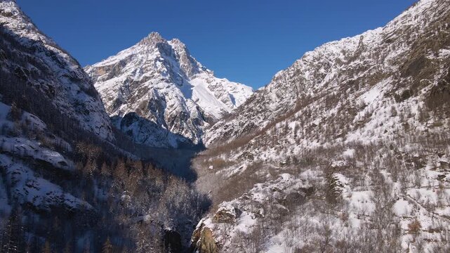Mont Pelvoux peak covered in snow in Ecrins National Park. Aerial view of frozen forest in winter. Vallouise and Ailefroide Valley, Hautes-Alpes (Alps) France