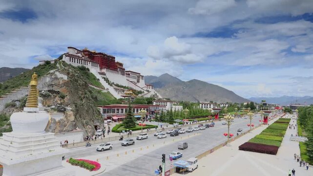 Potala Palace in Lhasa Tibet with traffic and pedestrians on Chang'an Road under partly cloudy sky